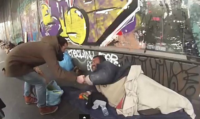 Levi geeft dakloze eten. Still uit zijn filmpje Erasmus Athens make the homeless people smile